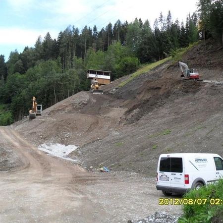 Bagger und Maschinen im Einsatz an einer Hangfläche