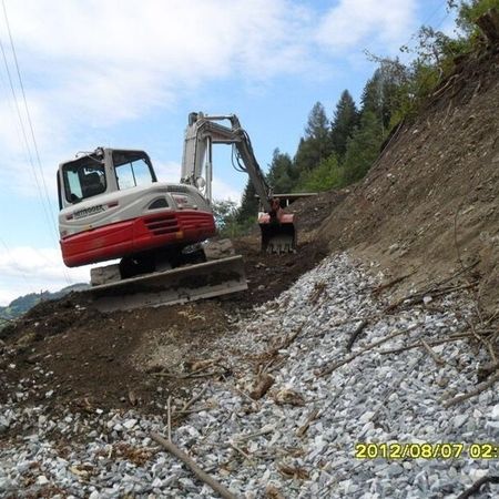 Bagger bei Erdarbeiten an einer steilen Böschung