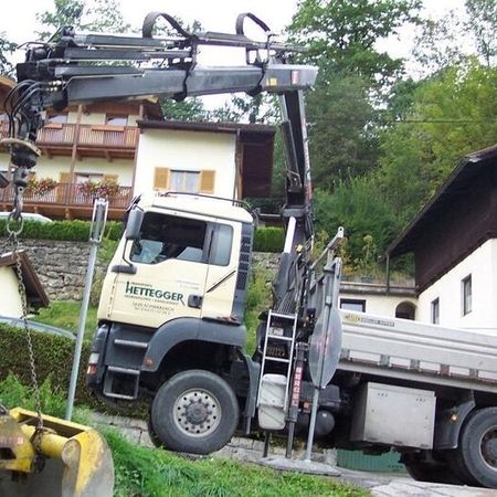 LKW mit Kran bei Arbeiten vor einem Gebäude
